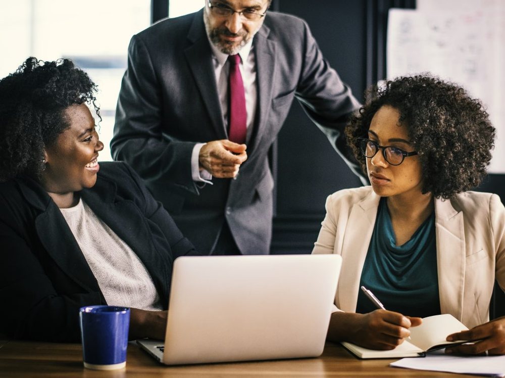 Consultants reviewing work together at a laptop